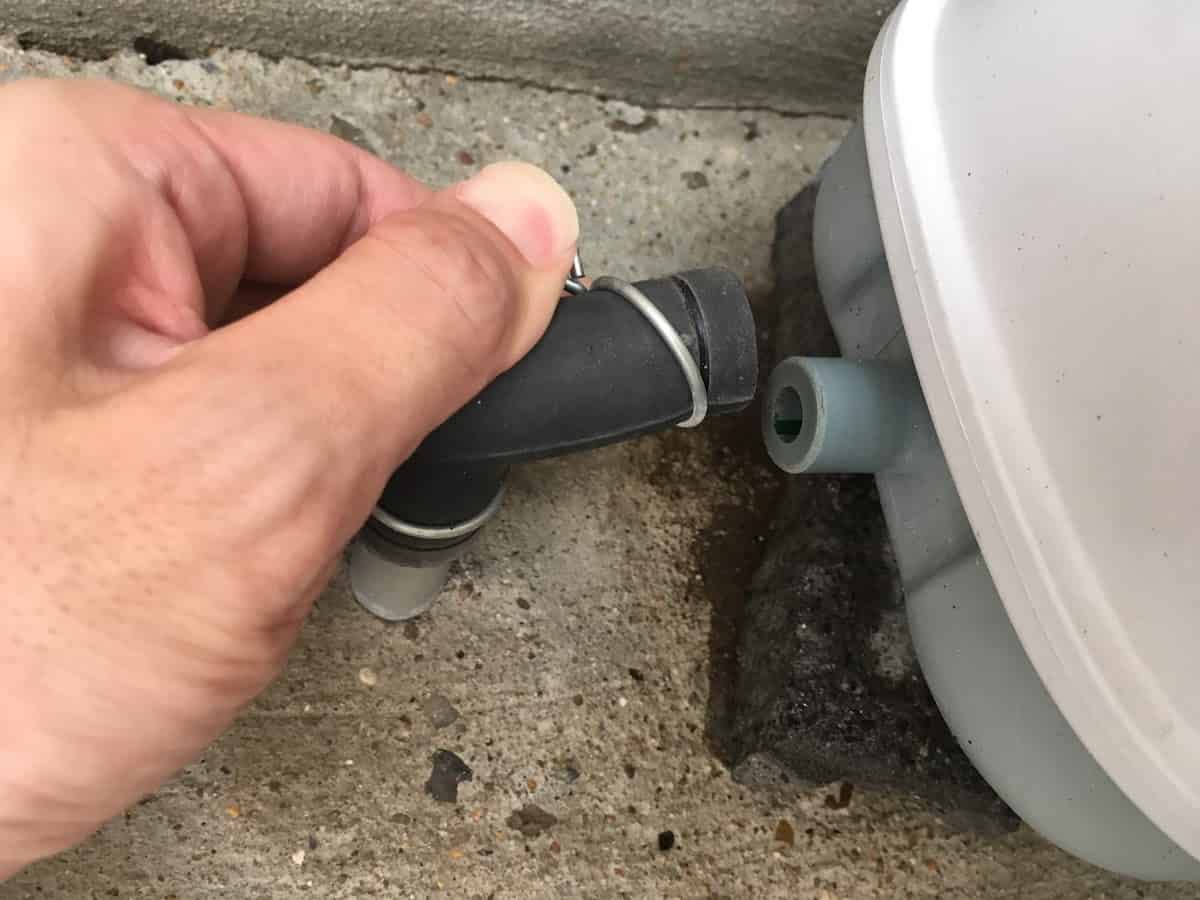 故障した浄化槽ブロアのゴムチューブを外して浄化槽との接続を切る