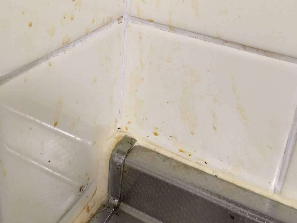 油汚れで汚れたキッチンのタイル壁と目地